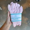 Hand holding light pink plant cleaning gloves