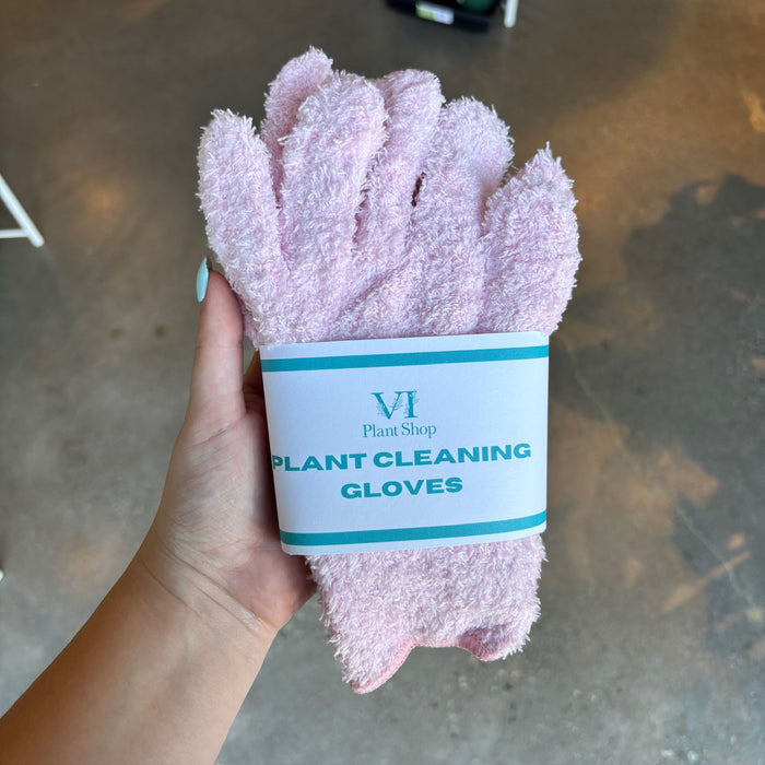 Hand holding light pink plant cleaning gloves