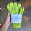 Hand holding lime green plant cleaning gloves