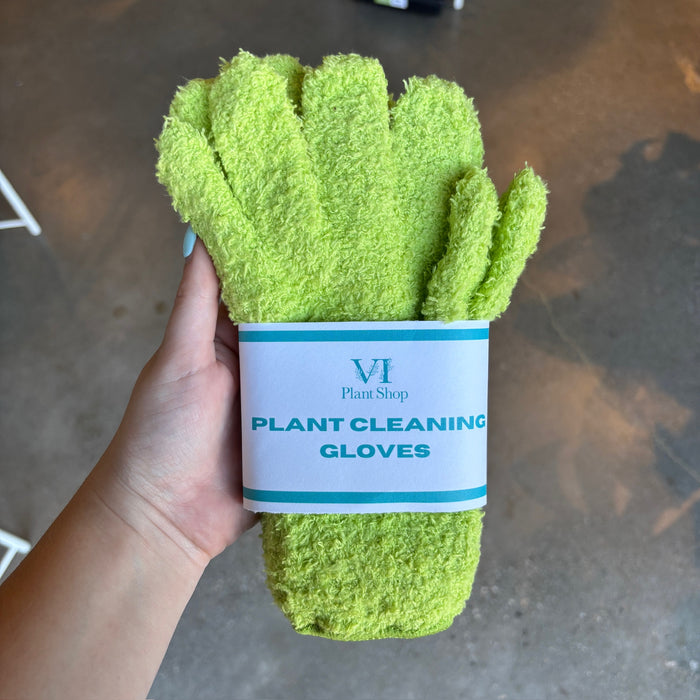 Hand holding lime green plant cleaning gloves