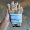 Hand holding tan plant cleaning gloves