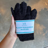Hand holding black plant cleaning gloves