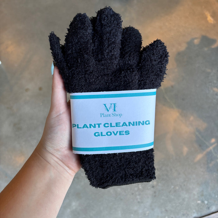 Hand holding black plant cleaning gloves