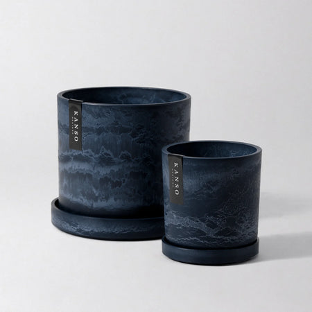 Two midnight blue Signature Stone planters with saucers