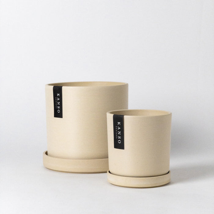 Two sand-coloured smooth finish planters with matching trays