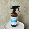 Houseplant Spray bottle with a blue label against a concrete wall