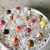 Glass mushroom spikes in white pebbles