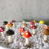 Red, orange and brown glass mushroom spikes in white pebbles